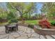 Lush backyard with stone patio, colorful landscaping, and mature trees for shade at 410 N Hyde Park Ave, Durham, NC 27703