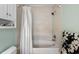 Bathroom featuring shower-tub combination with white tiles and modern shower curtain at 410 N Hyde Park Ave, Durham, NC 27703