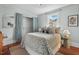 Cozy bedroom with natural light, patterned bedding, neutral walls, and closet with patterned curtains at 410 N Hyde Park Ave, Durham, NC 27703