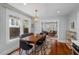 Dining room area with dark wood table, modern chandelier, and large windows with backyard views at 410 N Hyde Park Ave, Durham, NC 27703
