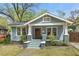 Charming blue craftsman home featuring a cozy front porch with brick accents and inviting curb appeal at 410 N Hyde Park Ave, Durham, NC 27703