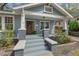 Inviting front porch featuring painted steps, brick columns, and wood door at 410 N Hyde Park Ave, Durham, NC 27703