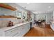 Bright kitchen featuring white cabinets, subway tile backsplash, floating shelves, and stainless dishwasher at 410 N Hyde Park Ave, Durham, NC 27703
