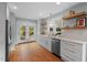 Bright kitchen with white cabinets, quartz countertops, stainless appliances, and French doors leading to backyard at 410 N Hyde Park Ave, Durham, NC 27703