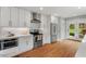 Updated kitchen with stainless appliances, white cabinets, and a view to the backyard at 410 N Hyde Park Ave, Durham, NC 27703