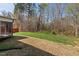 A well-maintained backyard has grass, tall trees, and a wooden fence at 433 Mockingbird Ln, Mebane, NC 27302