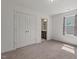 This bedroom has carpet, closet doors, and a window with curtains and leads to the bathroom at 433 Mockingbird Ln, Mebane, NC 27302