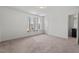 A bedroom has carpet, three windows with curtains, and an ensuite bathroom that contains a mirror at 433 Mockingbird Ln, Mebane, NC 27302