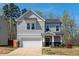Charming two-story home with a gray shingle facade, attached garage, and well-maintained landscaping at 433 Mockingbird Ln, Mebane, NC 27302