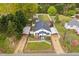 Charming home featuring dual driveways, carports, a fenced yard, outbuildings, and mature trees at 440 S Church St, Coats, NC 27521
