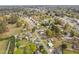 Expansive aerial view showcasing a neighborhood with mature trees, residential houses, and peaceful streets at 440 S Church St, Coats, NC 27521