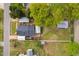 Aerial view of a home with a deck, outbuildings, and a large yard, set amongst lush greenery at 440 S Church St, Coats, NC 27521