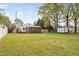 Wide view of the backyard showcasing the back deck, porch, shed, and large grassy lawn at 440 S Church St, Coats, NC 27521