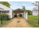 Front view of the carport with gravel driveway and white picket fence at 440 S Church St, Coats, NC 27521