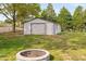 Detached garage sitting on a grassy lawn with a fire pit in the foreground at 440 S Church St, Coats, NC 27521