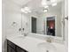 Bathroom featuring double sinks, a large mirror, white countertop, and a glimpse into the bedroom at 45 Pond Mountain Dr, Clayton, NC 27520