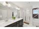 Well-lit bathroom with double vanity, framed mirrors, shower, and separate soaking tub at 45 Pond Mountain Dr, Clayton, NC 27520