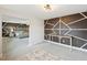 Bonus room with geometric accent wall, desk, and view into the primary bedroom at 45 Pond Mountain Dr, Clayton, NC 27520