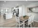 Open concept kitchen features white cabinetry, stainless appliances, island seating, and adjacent dining area at 460 Grand Silo Rd, Garner, NC 27603