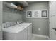 Well-lit laundry room featuring modern washer and dryer, overhead shelving and cute wall art at 480 Grand Silo Rd, Garner, NC 27603