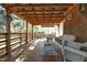 The back porch features seating, wood flooring, brick accents, and a covered roof at 5520 Mccormick Rd, Durham, NC 27713