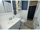 This bathroom has a vanity with blue wooden walls, tiled shower, and wood-look floors at 5520 Mccormick Rd, Durham, NC 27713