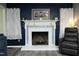 Close up of the fireplace with navy blue accents and white mantel at 5520 Mccormick Rd, Durham, NC 27713