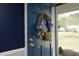 Charming blue front door adorned with a colorful floral wreath, creating a warm and inviting entry at 5520 Mccormick Rd, Durham, NC 27713