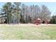 Community playground featuring swings and climbing structures surrounded by a grassy field at 5520 Mccormick Rd, Durham, NC 27713