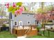 Charming backyard with a wood deck and blooming trees offering outdoor enjoyment and curb appeal at 5608 Ventura Dr, Durham, NC 27712