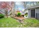 Well maintained backyard landscape featuring stone retaining wall, greenery and detached garage at 5608 Ventura Dr, Durham, NC 27712