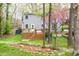 Back of gray home with deck, steps, trees, and attractive landscaping with rock border at 5608 Ventura Dr, Durham, NC 27712