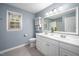 Bright bathroom featuring a double sink vanity with modern fixtures, stylish decor, and gray tile floors at 5608 Ventura Dr, Durham, NC 27712