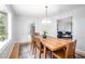 Elegant dining room with a modern chandelier, hardwood floors, and seamless access to the living room and kitchen at 5608 Ventura Dr, Durham, NC 27712