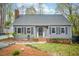 Inviting gray home with black shutters, brick accents, and manicured landscaping enhancing curb appeal at 5608 Ventura Dr, Durham, NC 27712