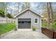 Detached gray garage with glass panel door, concrete driveway and decorative potted plants at 5608 Ventura Dr, Durham, NC 27712