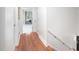 Bright hallway with hardwood floors leading to a room with a work desk and chair at 5608 Ventura Dr, Durham, NC 27712