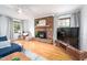 Spacious living room featuring a brick fireplace, hardwood floors, and ample natural light at 5608 Ventura Dr, Durham, NC 27712