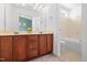 Bright bathroom featuring double sinks, a large mirror, and a separate toilet and shower area at 5980 Osprey Cove Dr, Raleigh, NC 27604