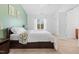 Bright bedroom with a comfortable bed, a soothing green accent wall, and natural light at 5980 Osprey Cove Dr, Raleigh, NC 27604