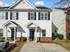 Traditional two-story townhouse featuring white siding, black shutters and door with covered front porch at 5980 Osprey Cove Dr, Raleigh, NC 27604