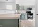 Modern kitchen features stainless steel appliances, light countertops, and sage-colored cabinets at 5980 Osprey Cove Dr, Raleigh, NC 27604