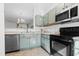 Modern kitchen features stainless steel appliances, tile floors, and sage-colored cabinets at 5980 Osprey Cove Dr, Raleigh, NC 27604