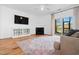Bright living room featuring a fireplace, wood floors, area rug, and sliding glass doors at 5980 Osprey Cove Dr, Raleigh, NC 27604