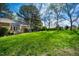 A lush green backyard features mature trees and landscaping with a deck for outdoor enjoyment at 6 Preakness Dr, Durham, NC 27713