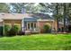 A backyard features a deck with seating, a lush lawn, and mature landscaping at 6 Preakness Dr, Durham, NC 27713