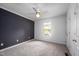 Bedroom featuring large window, ceiling fan, and a dark accent wall at 6 Preakness Dr, Durham, NC 27713