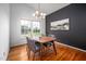 Bright dining room with modern lighting, hardwood floors, and a chic accent wall at 6 Preakness Dr, Durham, NC 27713