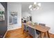 Open-concept dining area with hardwood floors, modern light fixture, and view to the living room at 6 Preakness Dr, Durham, NC 27713