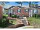 Charming brick home featuring blue shutters, a bay window, a manicured lawn, and inviting front steps at 6 Preakness Dr, Durham, NC 27713